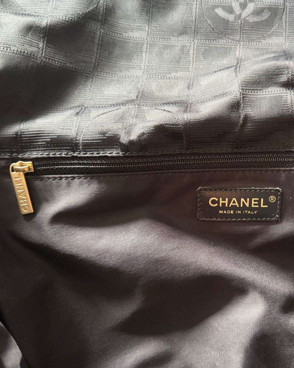 CHANEL® logo label on dark nylon messenger bag with top zipper