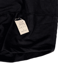 Black T-shirt with fabric drape and size/brand neck label close-up