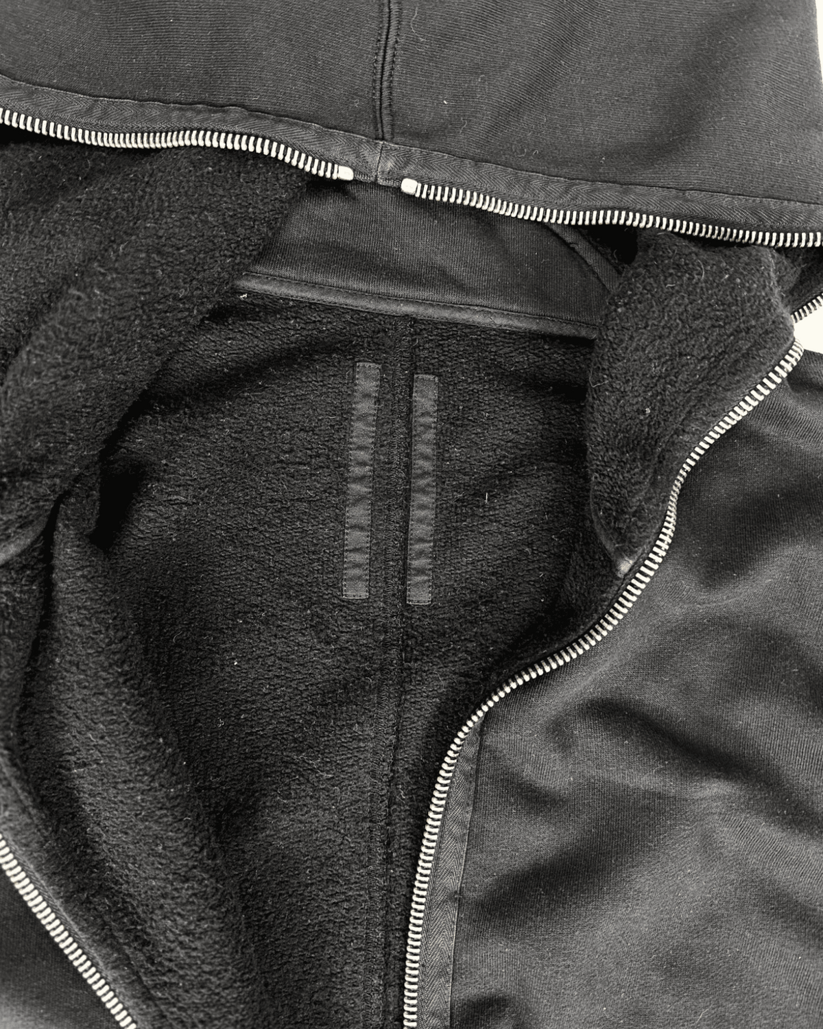 Dark hybrid hoodie close-up of front zip and fleece-lined interior panel