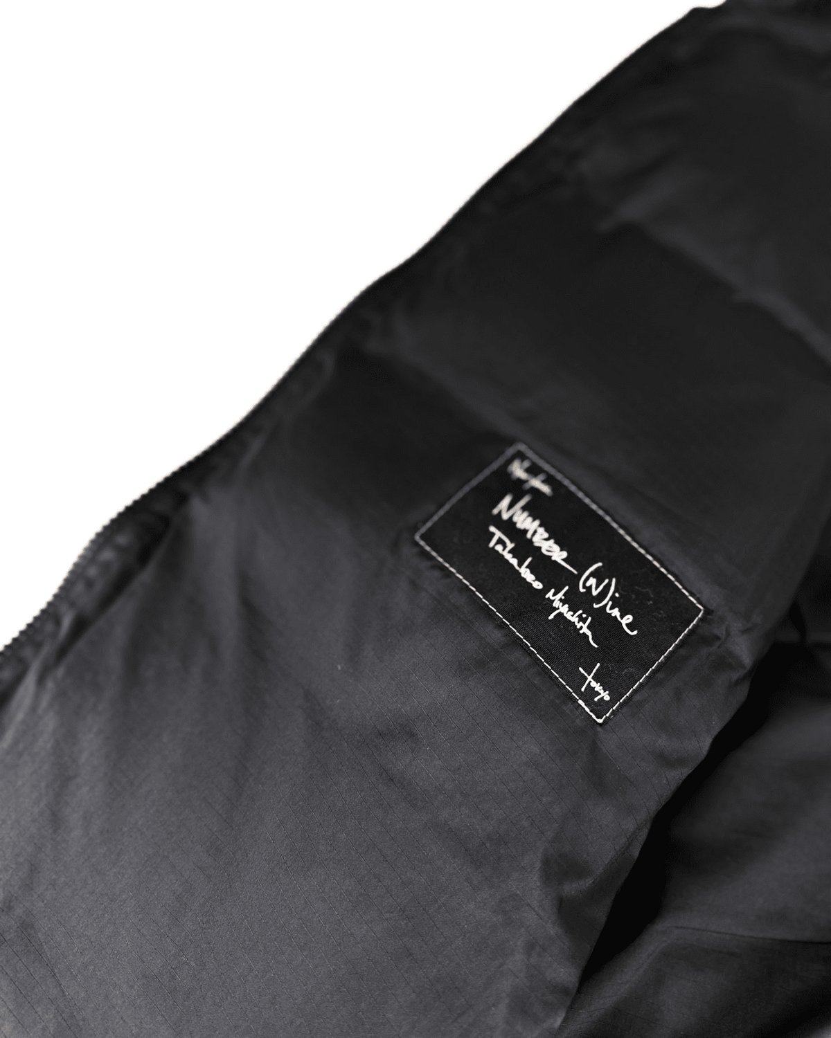 Black puffer vest fabric with embroidered logo patch