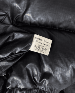 Black puffer vest fabric label with size and care details