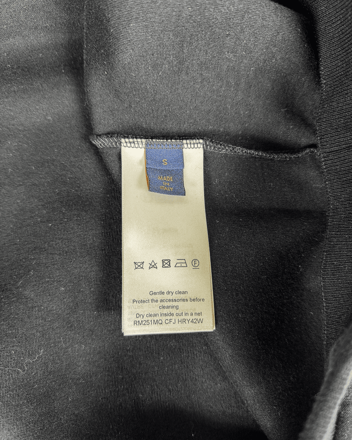 Care label on inside black zip-up hoodie