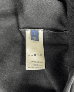 Care label on inside black zip-up hoodie