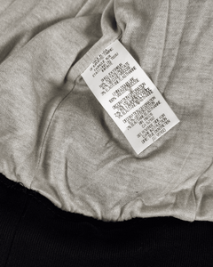 Interior care label tag on light-beige bomber, ribbed black hem and cuffs