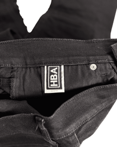 Distressed black denim jeans with HBA label at waistband and metal button