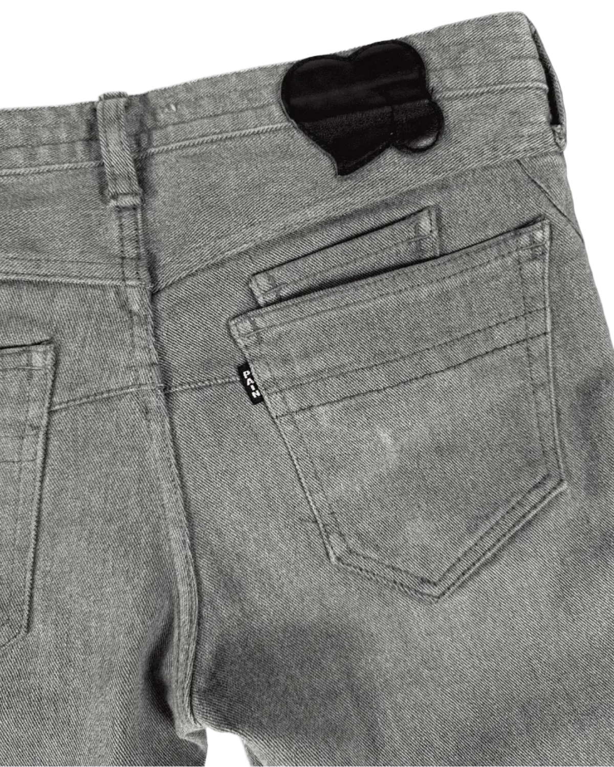 Grey denim jeans back pocket with heart-shaped cutout patch and belt loop