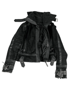 Dark high-collar buckle jacket with quilted panels, front zipper, and wide belt straps