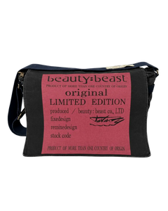 Dark messenger bag with front printed pink panel and gold-tone zipper pull