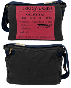 Black messenger bag, front zipper pocket, blue side straps and gold-tone hardware