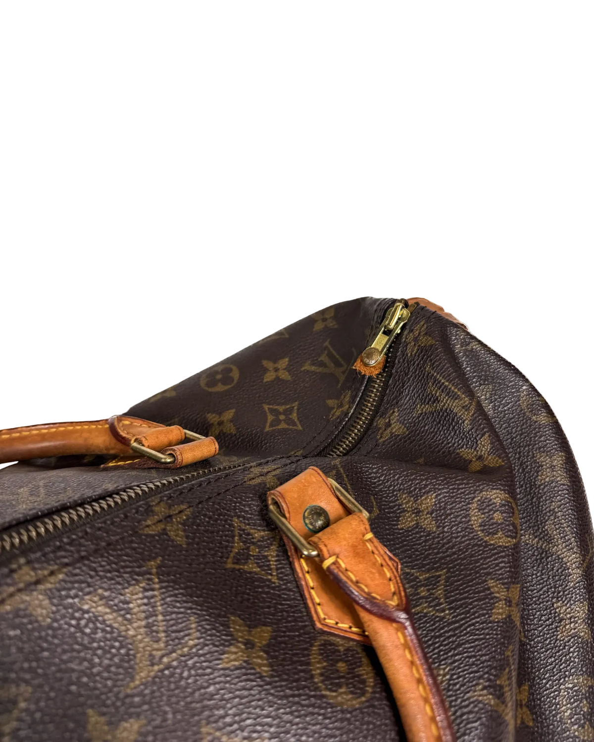 Louis Vuitton duffle bag close-up of tan leather tab and gold zipper hardware