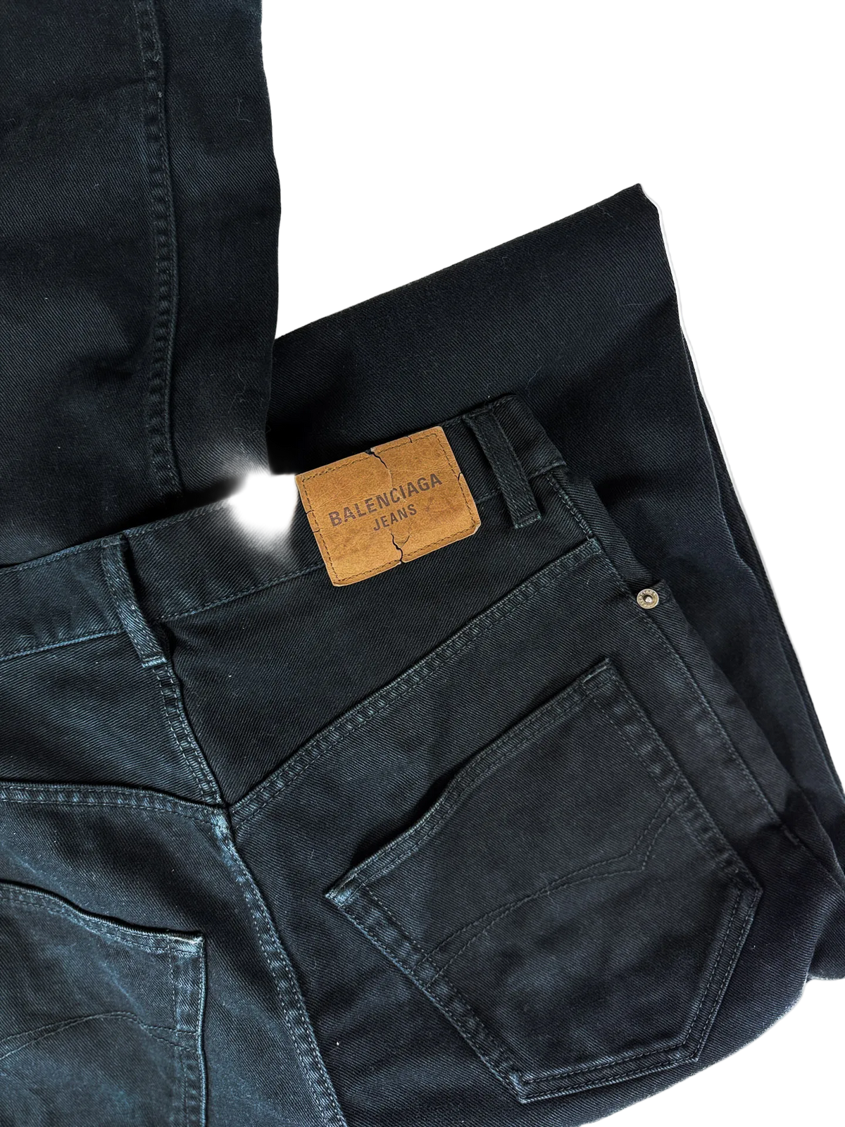 Black denim jeans with stitched front pockets and leather Balenciaga patch.