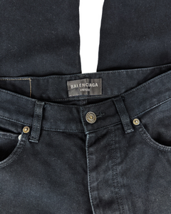Black denim jeans waist with Balenciaga logo label and gold button.