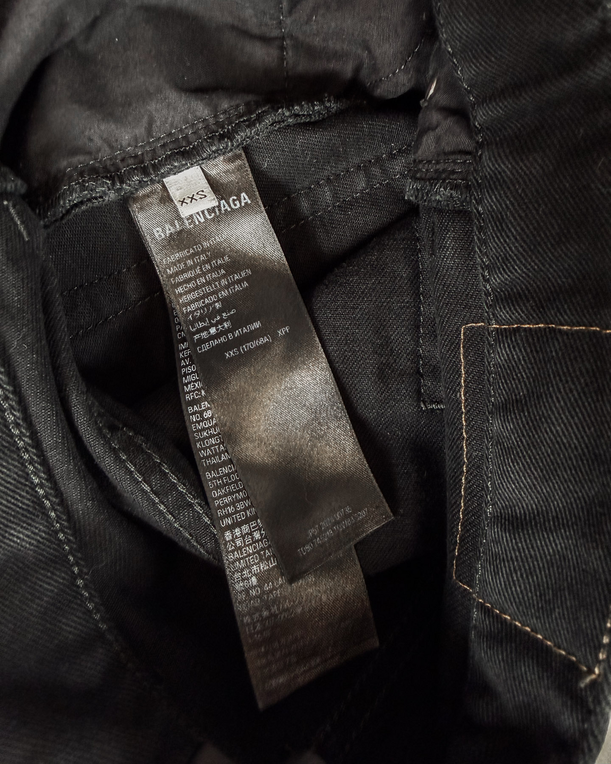 Balenciaga jeans care label inside dark denim waistband.