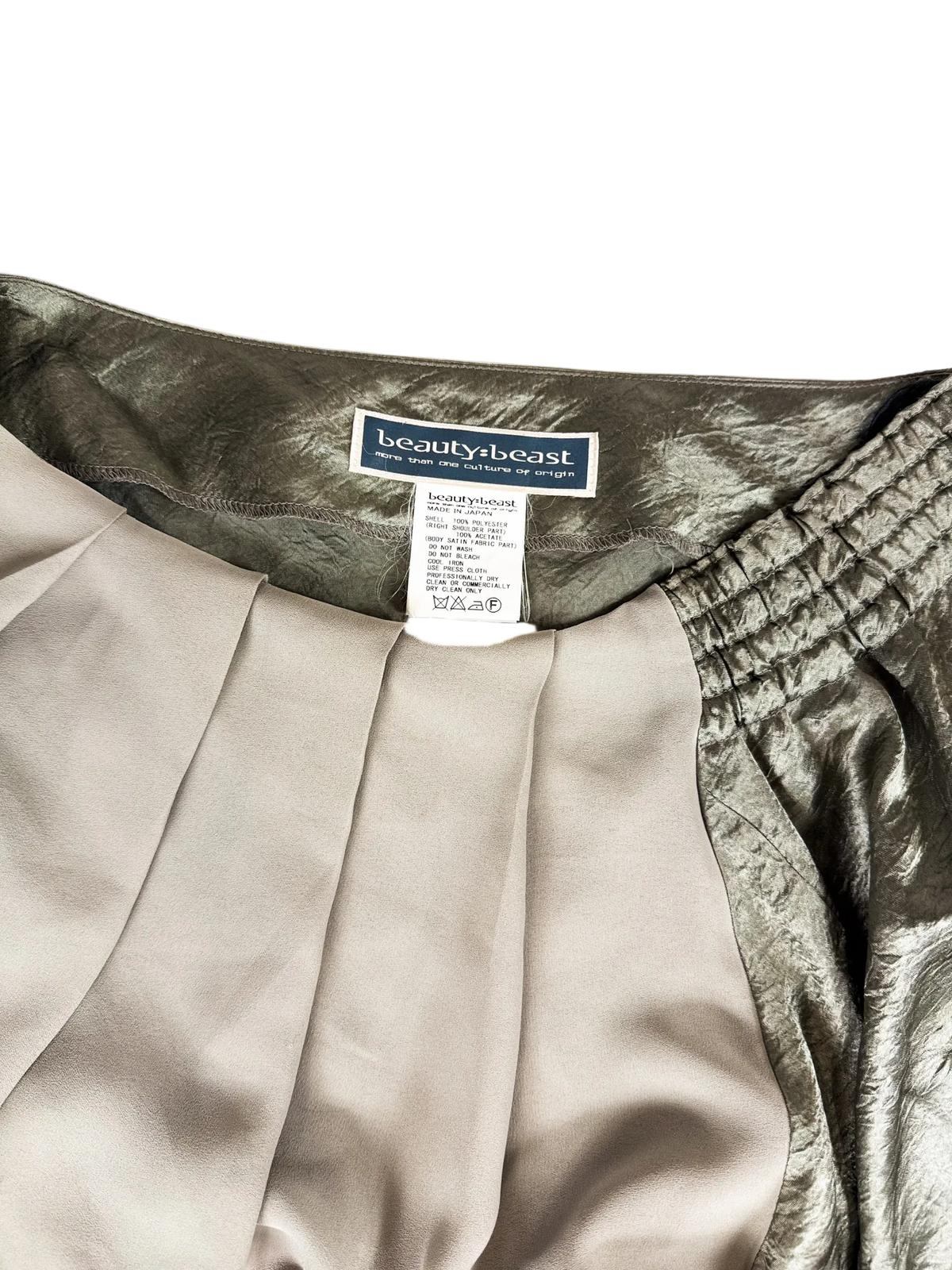 Off-shoulder neckline with gathered elastic and brand label on metallic top