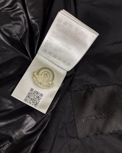 Moncler logo patch and care tag on dark black jacket fabric