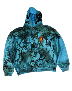 Blue zip-up hoodie with graphic scribble print and crest patch, pullover hood