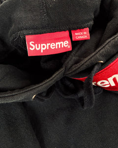 Black hoodie neckline with Supreme label and red Made in Canada tag
