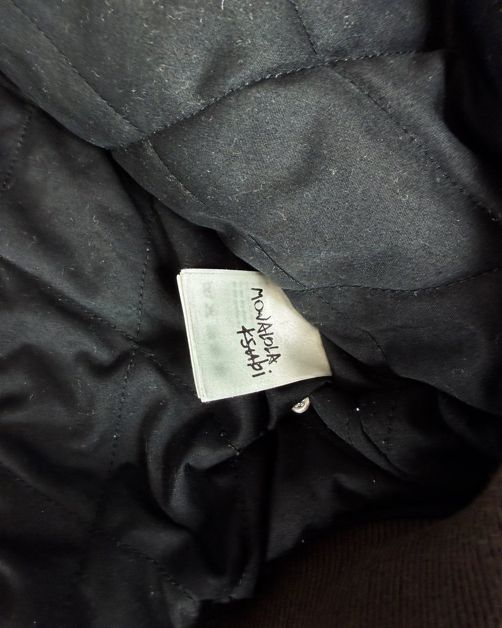 Black bomber jacket lining with woven size/brand label tag