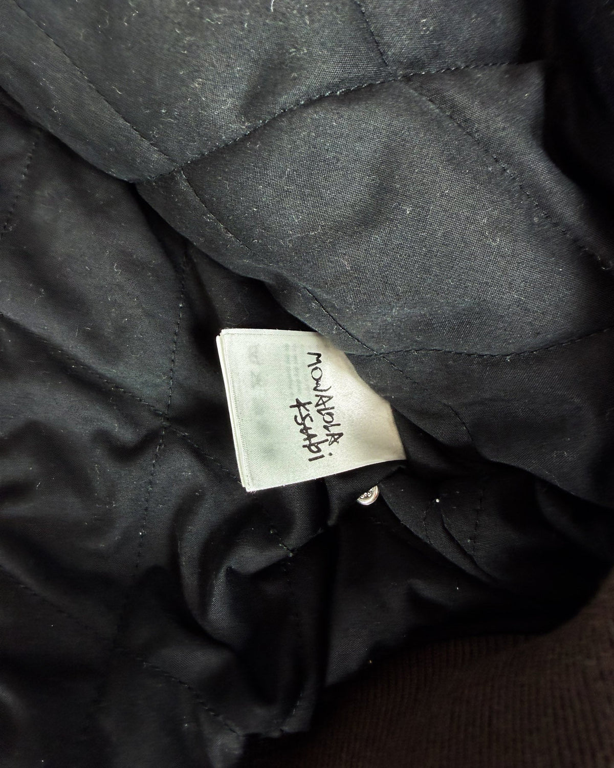 Black bomber jacket lining with woven size/brand label tag